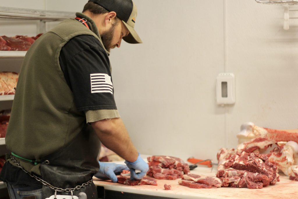 Nate Peterson of Nate's Custom Farm Butchering cutting for a local grass-fed producer.